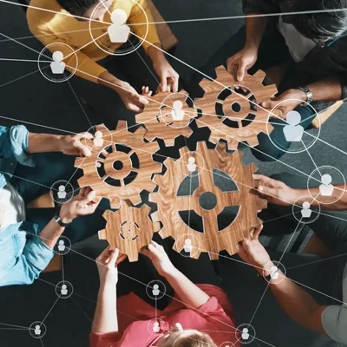 A team assembling interlocking wooden gears together